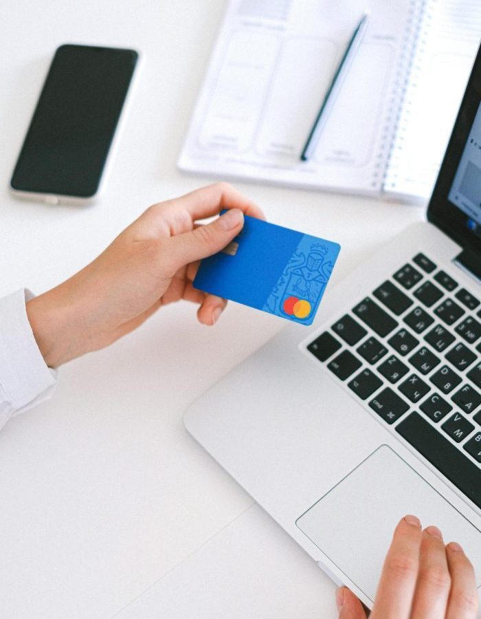Person making an online purchase with a credit card on a laptop, showcasing modern ecommerce technology.